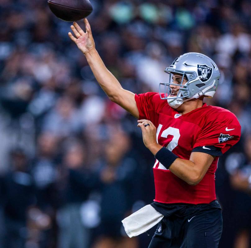 Raiders quarterback Aidan O'Connell (12) gets off a pass during an open practice at Allegiant S ...