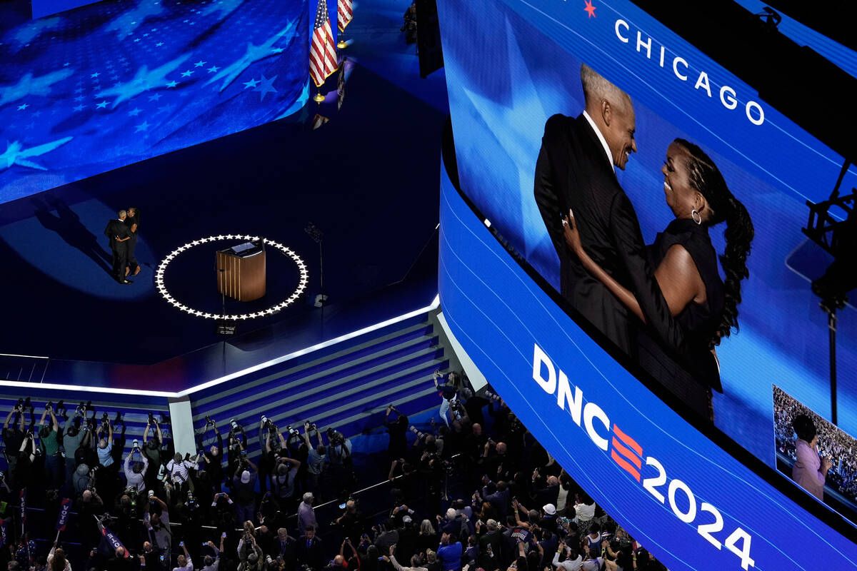 Former President Barack Obama hugs his wife Former First Lady Michelle Obama during the Democra ...