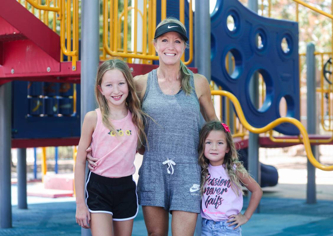 Kim Benitez, who suffered a stroke at age 35, center, poses for a portrait with her daughters A ...