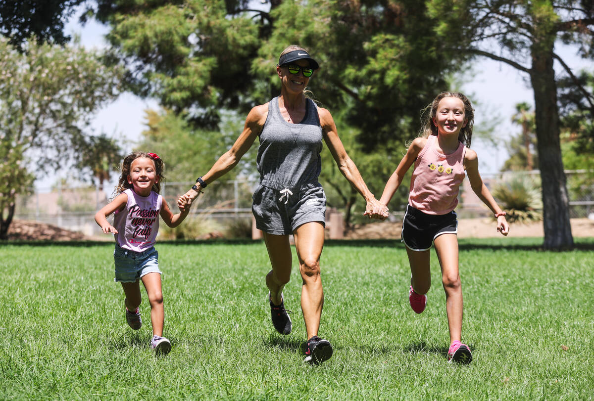 Kim Benitez, who suffered a stroke at age 35, center, runs with her daughters Carlee Benitez, 5 ...