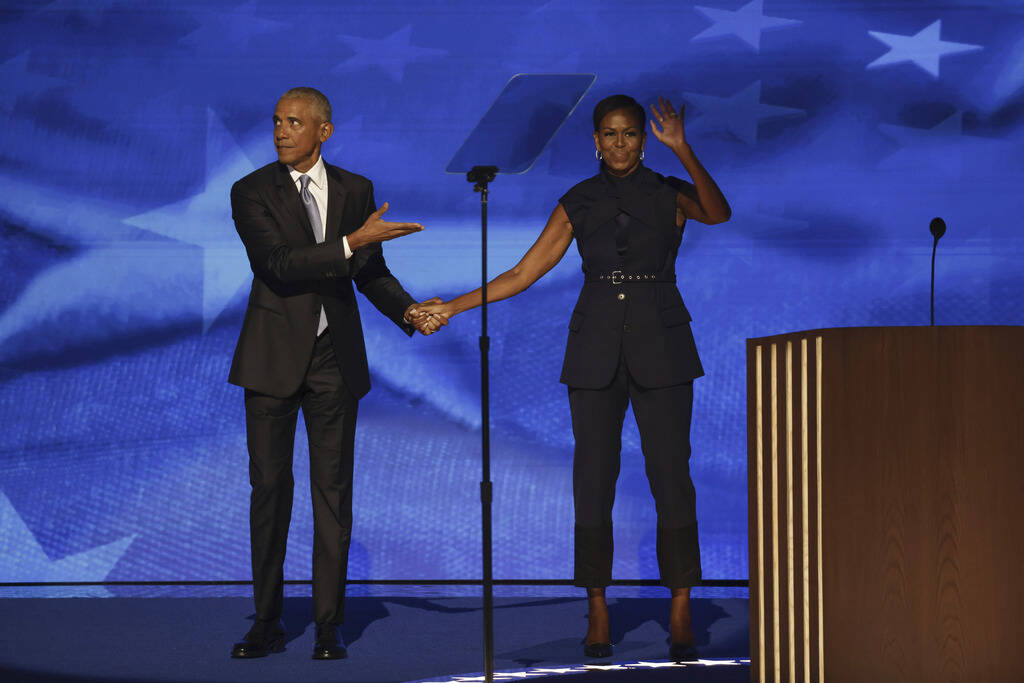 Former President Barack Obama, left, greets former first lady Michelle Obama before speaking du ...