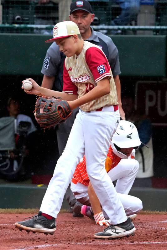 Henderson, Nev.'s Wyatt Erickson, center, walks back to the mound after being unable to tag out ...