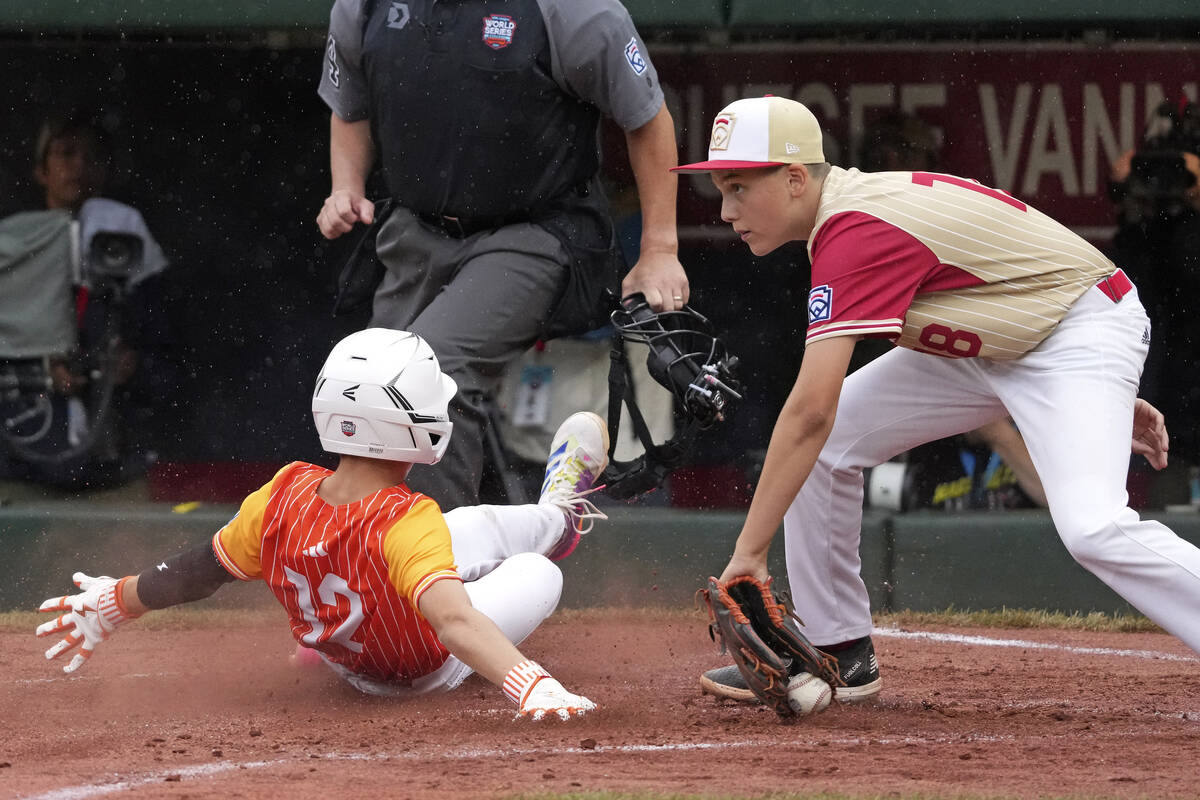 Boerne, Texas' Gage Steubing (12) scores past Henderson, Nev.'s Wyatt Erickson (18) on a single ...