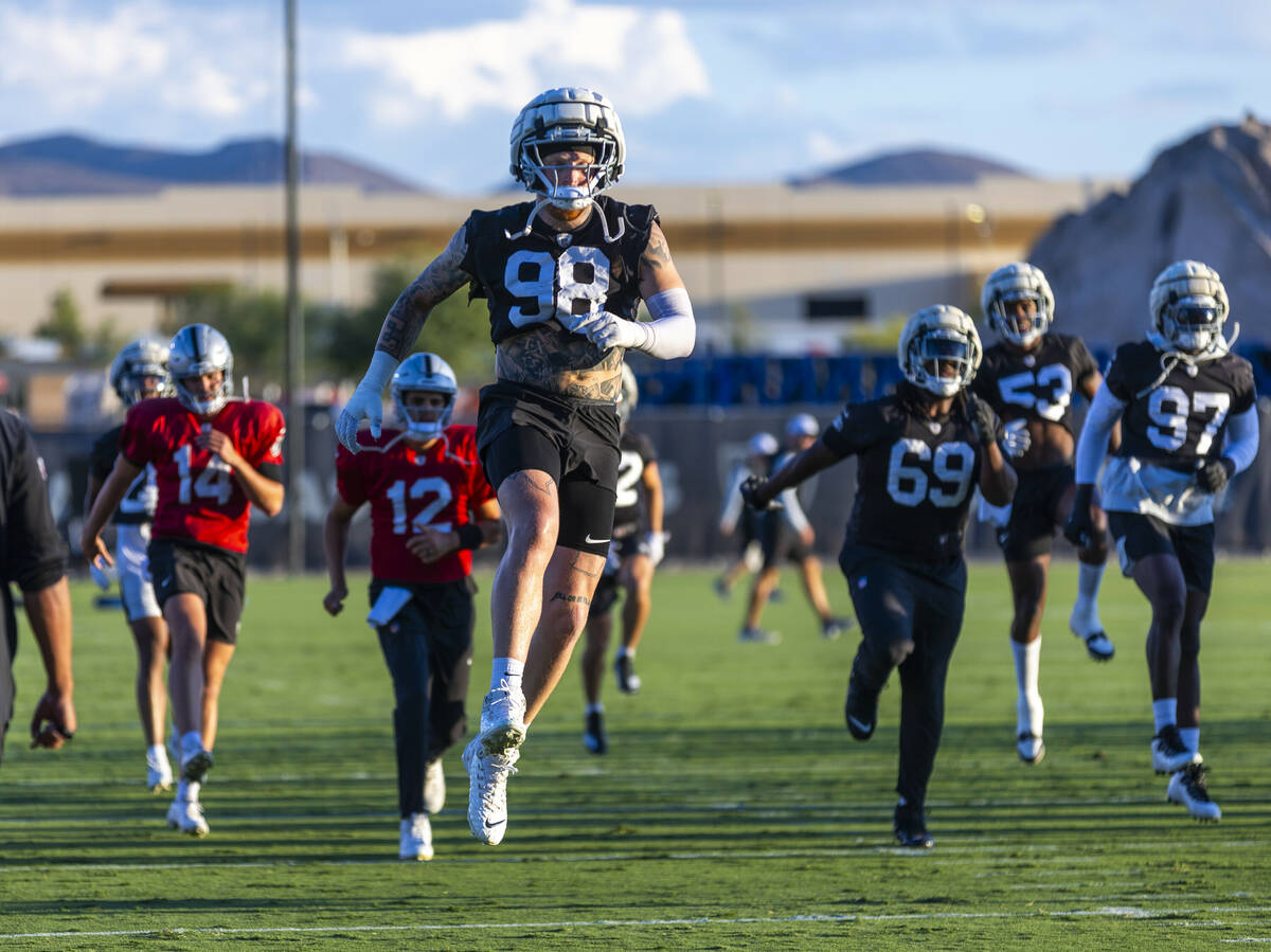 Raiders defensive end Maxx Crosby (98) catches some air during warm ups at practice in the Inte ...