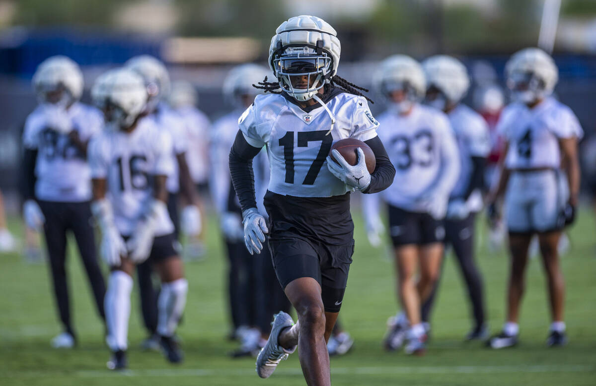 Raiders wide receiver Davante Adams (17) runs after catching a pass during practice at the Inte ...