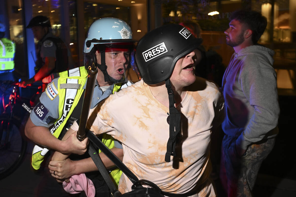 A demonstrators is taken into custody by police near the Israeli Consulate during the Democrati ...