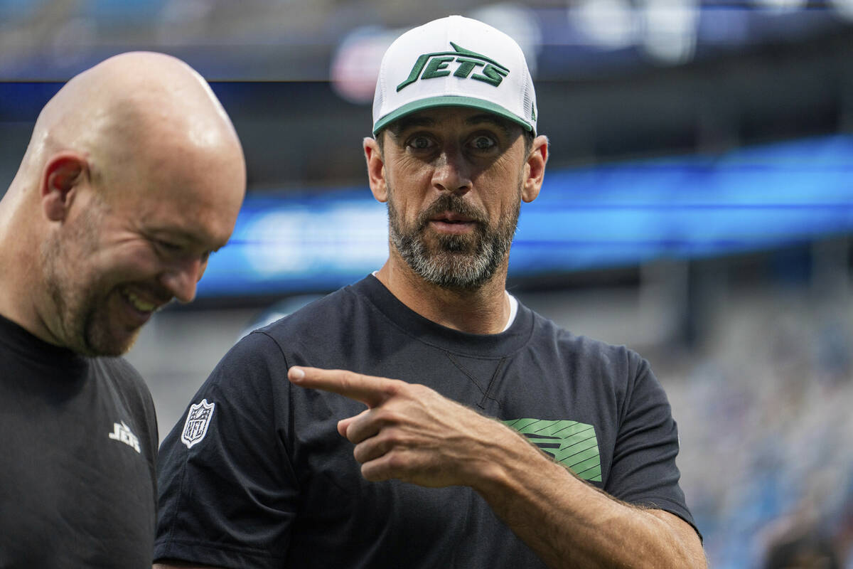 New York Jets quarterback Aaron Rodgers, right, gestures toward defensive line coach Aaron Whit ...