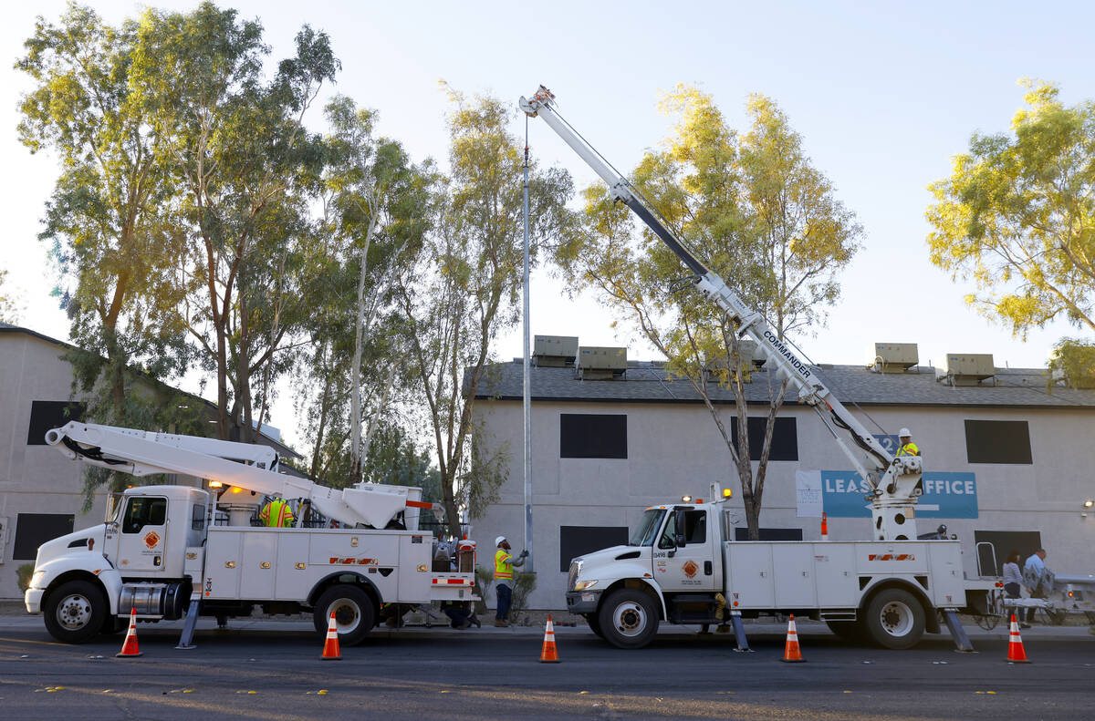 Workers from Clark County’s Public Works Department install one of the 12 new solar streetlig ...