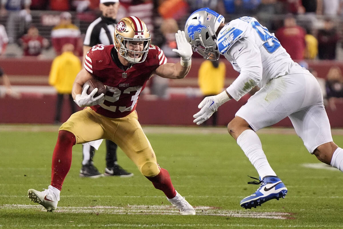 San Francisco 49ers running back Christian McCaffrey, left, fends off San Francisco 49ers defen ...