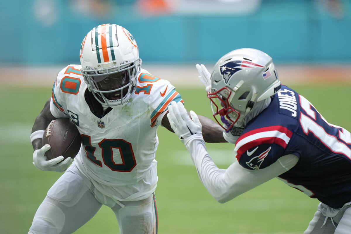 Miami Dolphins wide receiver Tyreek Hill (10) holds off New England Patriots cornerback Jack Jo ...