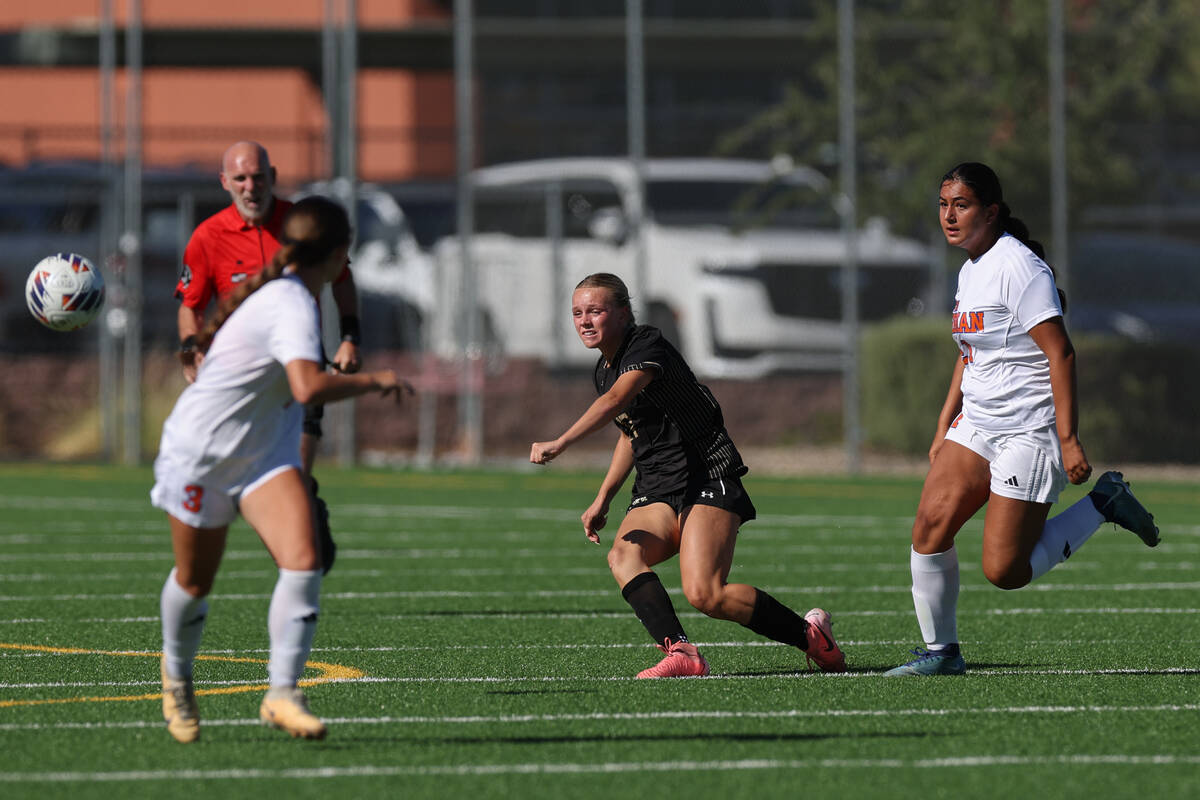 Faith Lutheran striker Julia Anfinson, center, passes up the field against Bishop Gorman&#x2019 ...