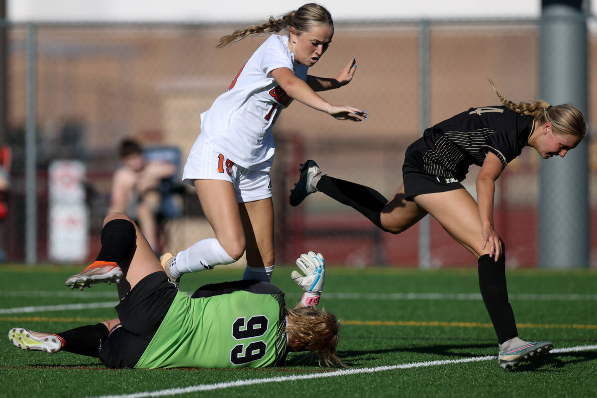 Bishop Gorman’s Riley Rohr (19) and Faith Lutheran’s Kloe Abdalla (14) tumble ove ...