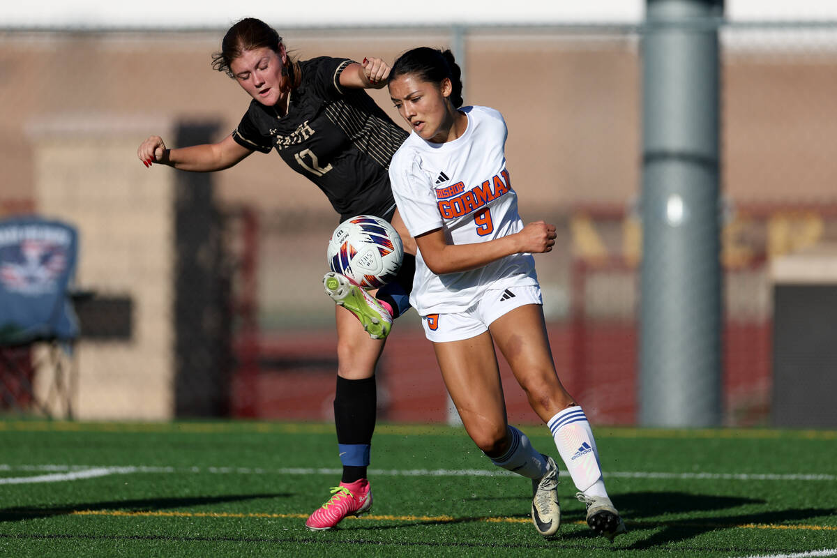 Faith Lutheran’s Vienna Niotta (12) kicks the ball away from Bishop Gorman’s Alan ...