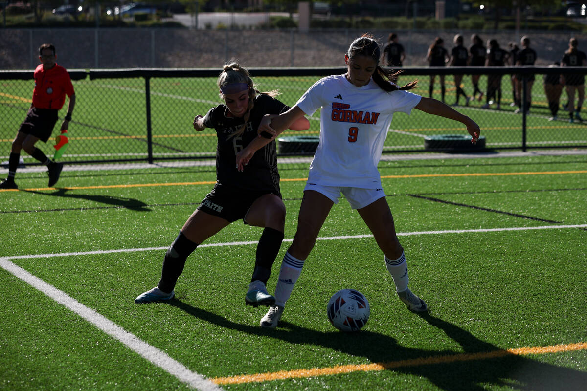 Faith Lutheran’s Jacey Phillips (6) and Bishop Gorman’s Alana Moore (9) work to k ...