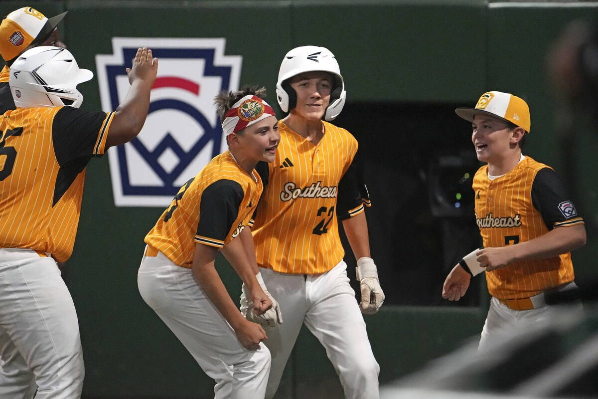 Lake Mary, Fla.'s Garrett Rohozen (22) returns to the dugout after hitting a solo home run off ...