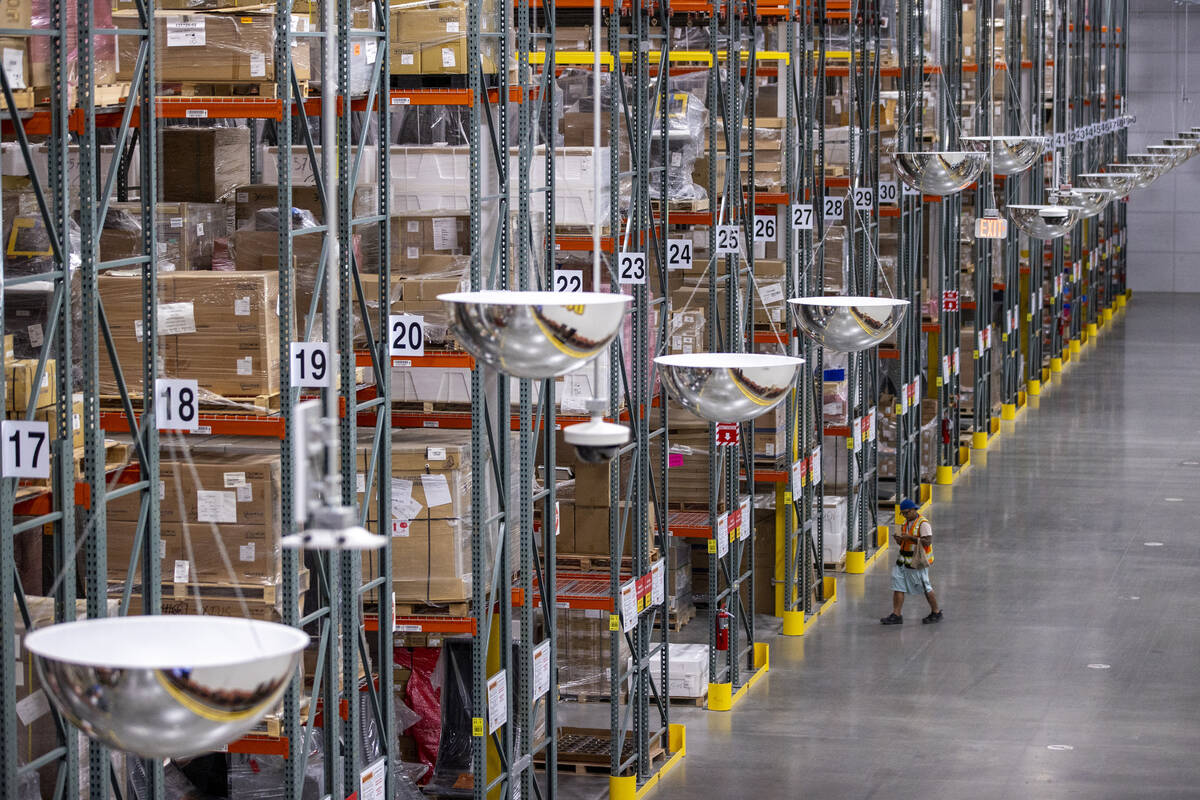 Workers walk through the rows of storage shelves at the new Aristocrat Gaming™ manufactu ...