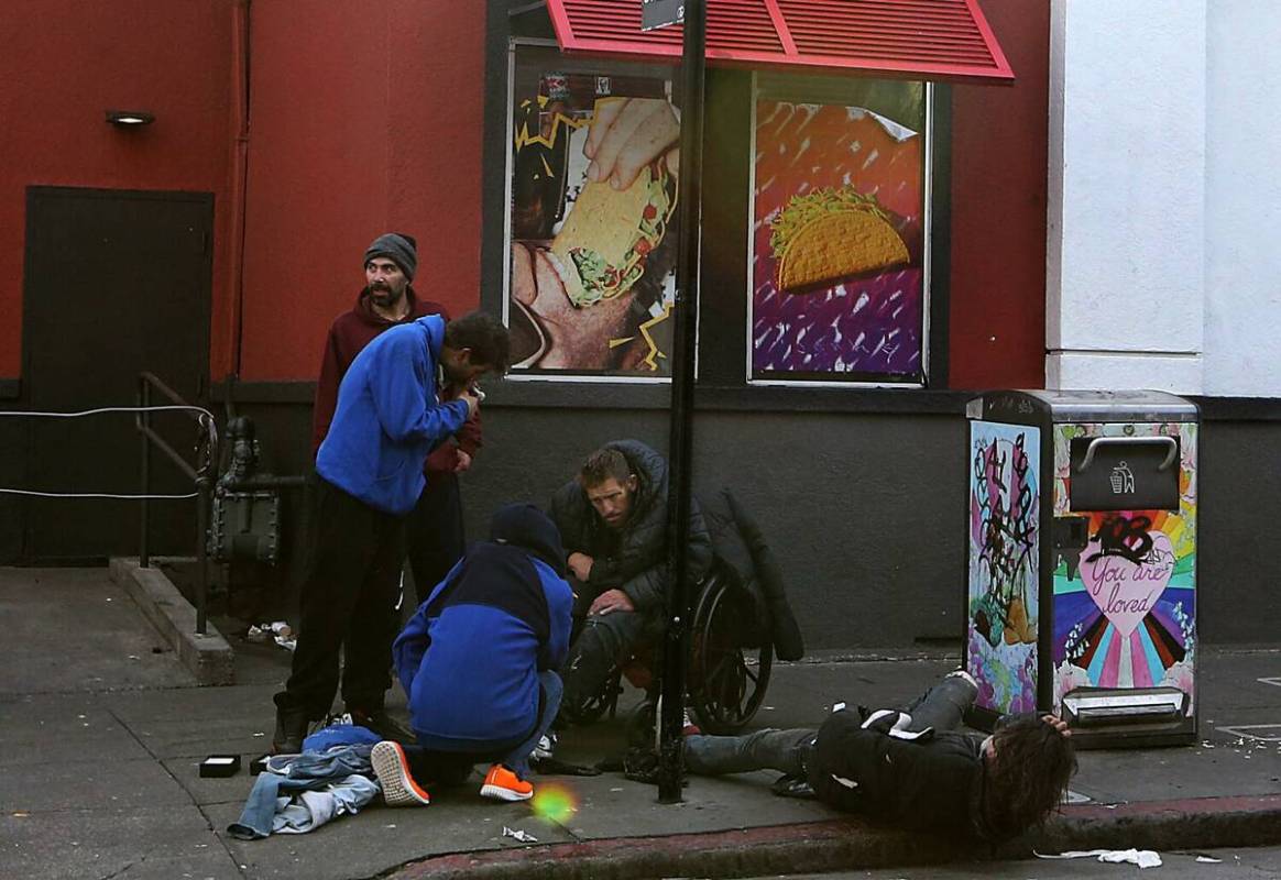 A group of men loiter and use drugs outside a fast food restaurant in the Tenderloin district o ...