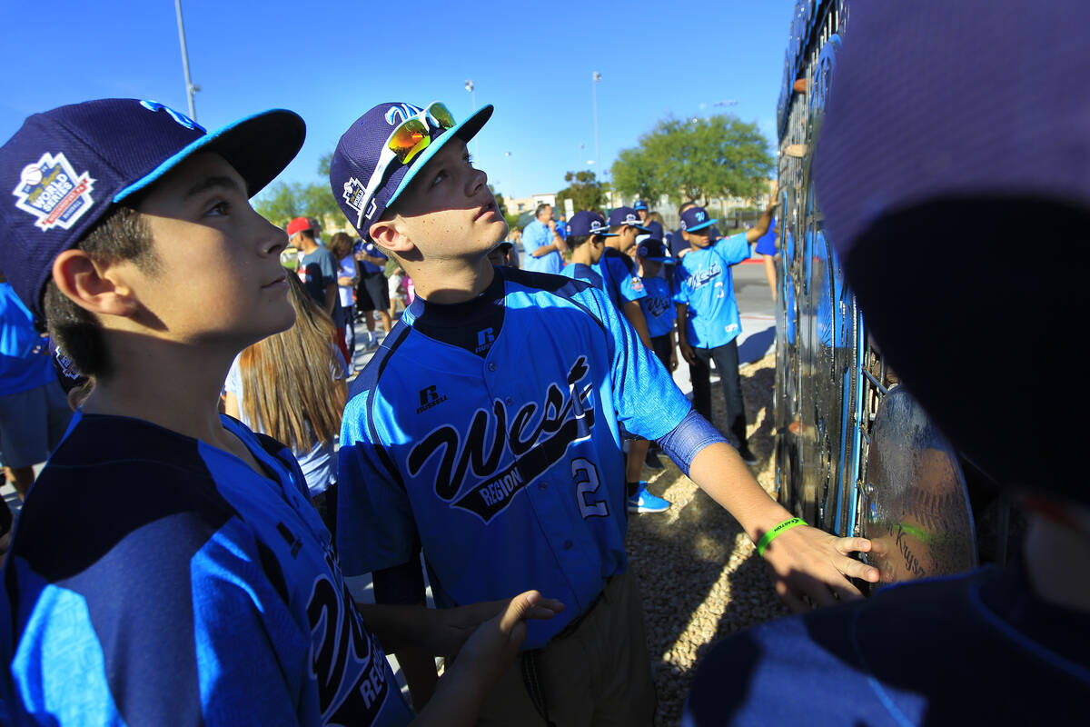 Mountain Ridge Little Leauge player Austin Kryszczuk, center, examines a monument dedicated to ...