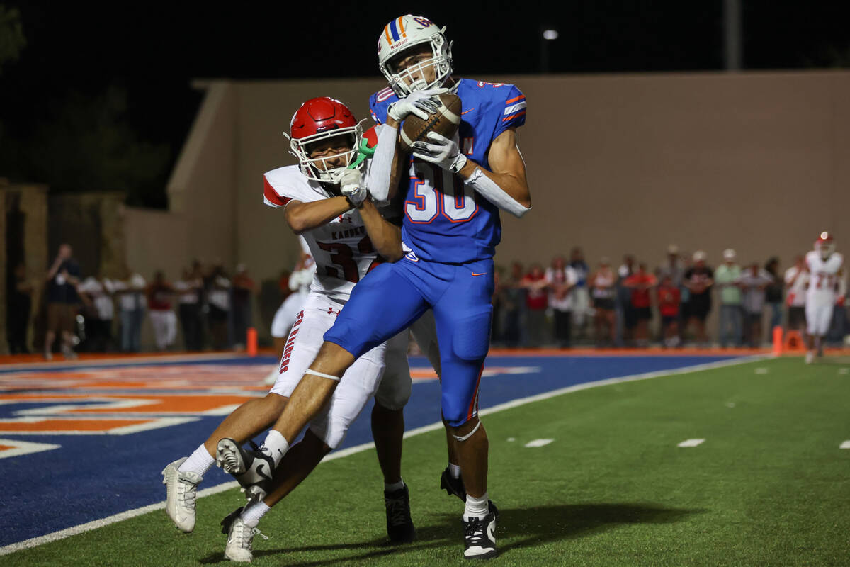 Bishop Gorman wide receiver Derek Meadows (30) catches the ball while Kahuku defensive back Lon ...