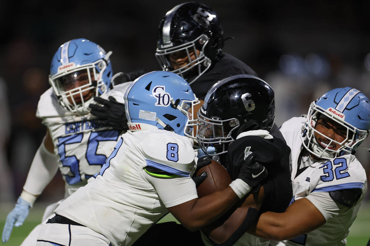 Centennial linebacker Jeremy Evans (8) and defensive end Preston Kaneao (32) tackle Desert Pine ...