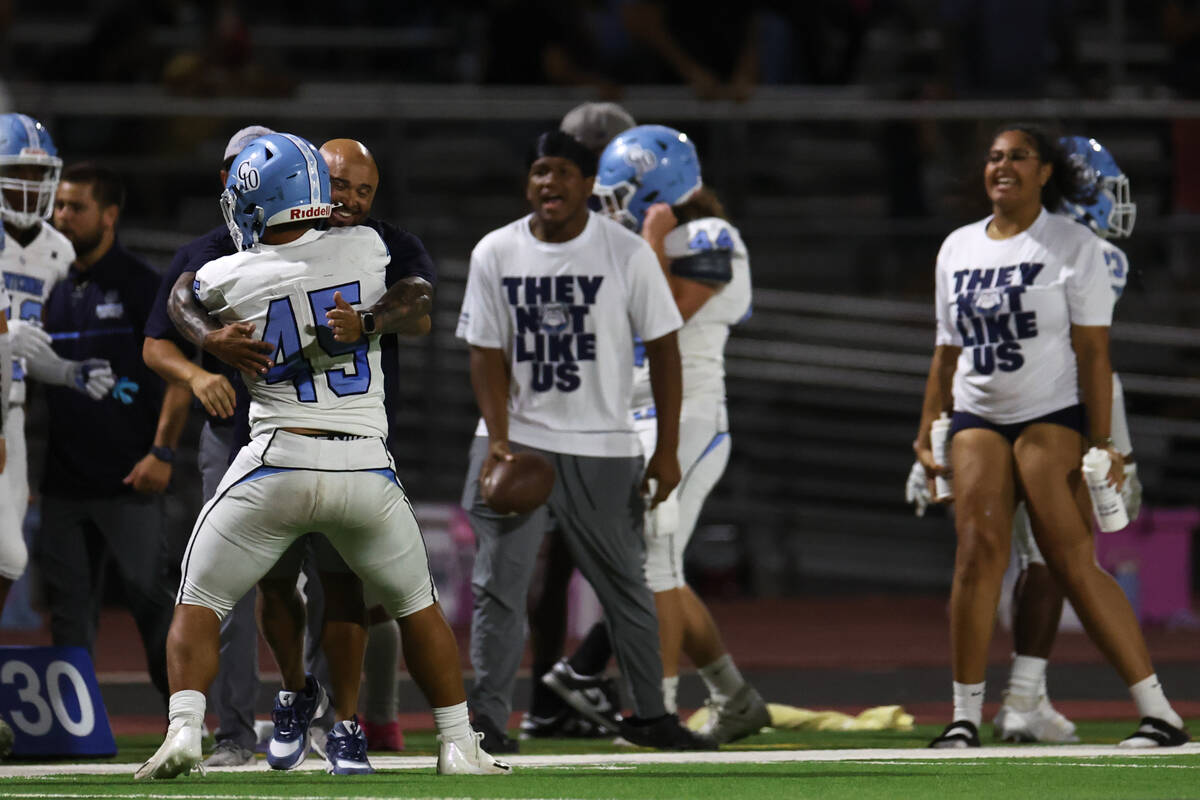 Centennial running back Kolten Silbernagel (45) celebrates with his coach after scoring during ...