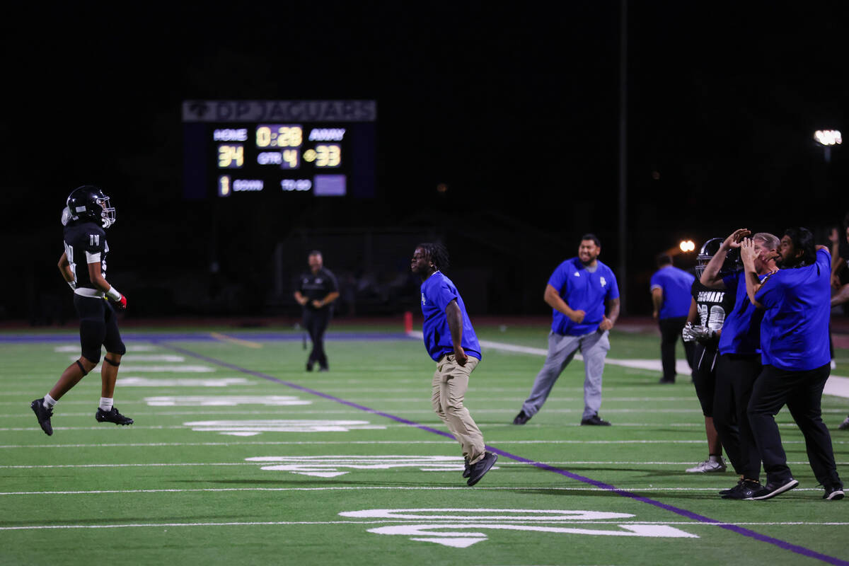 Desert Pines wide receiver Jaisun Gill (3) runs into a gaggle of celebratory coaches as they wi ...