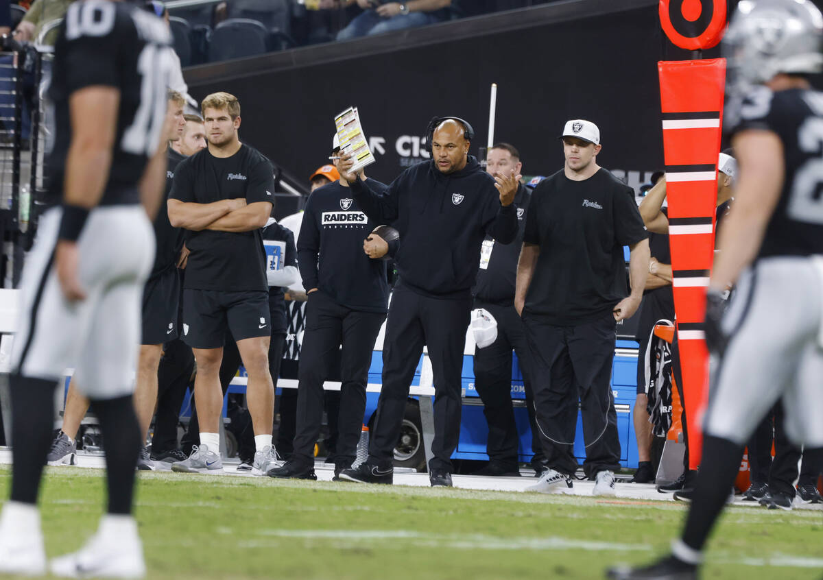 Raiders head coach Antonio Pierce center, reacts from the sideline as he watches his players wa ...