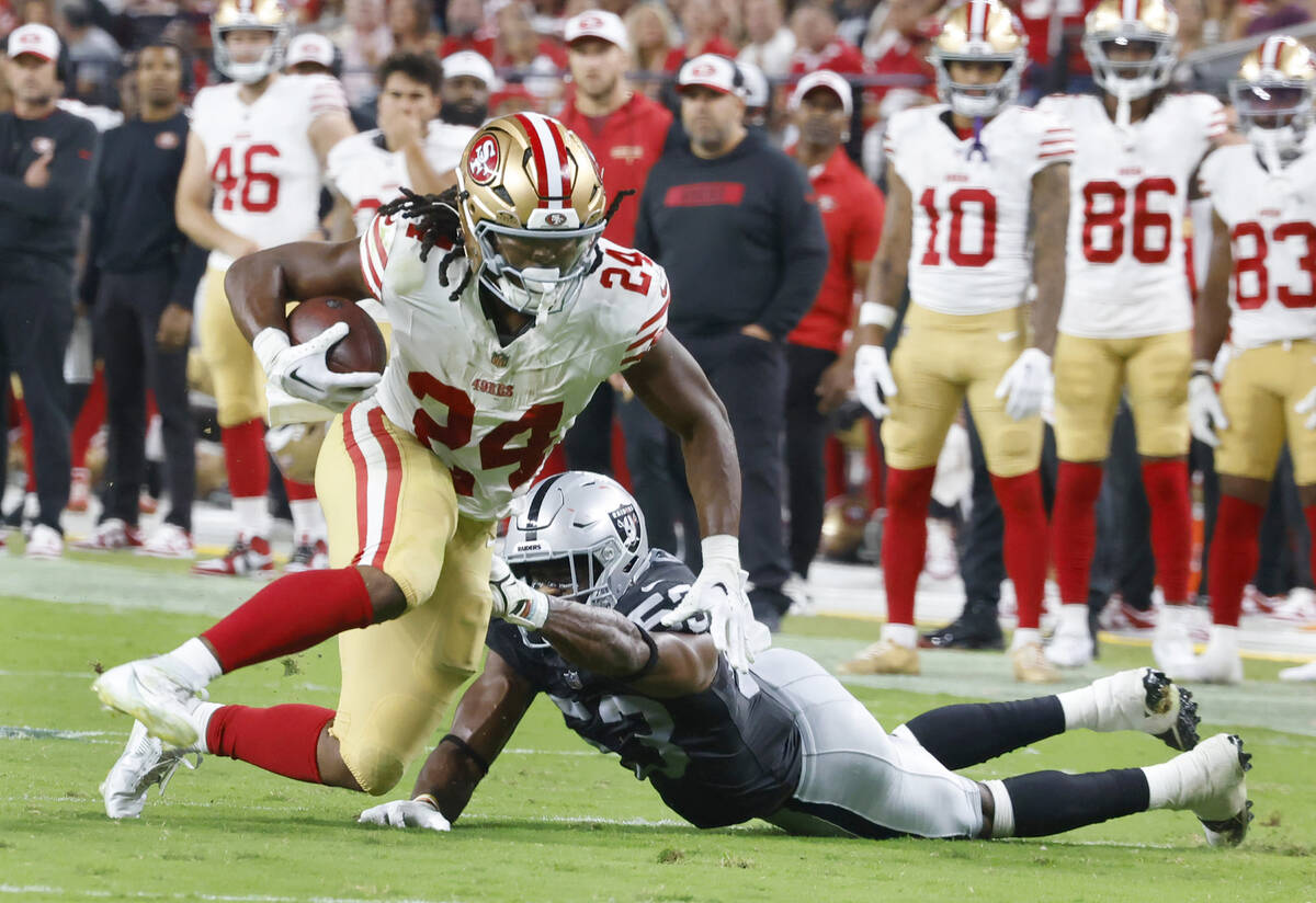 San Francisco 49ers running back Jordan Mason (24) runs past Raiders linebacker Amari Gainer (5 ...