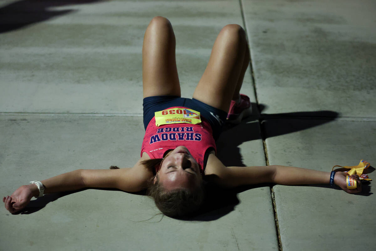 Shadow Ridge’s Elynn Okuda lays on the pavement after finishing the Red Rock Running Com ...