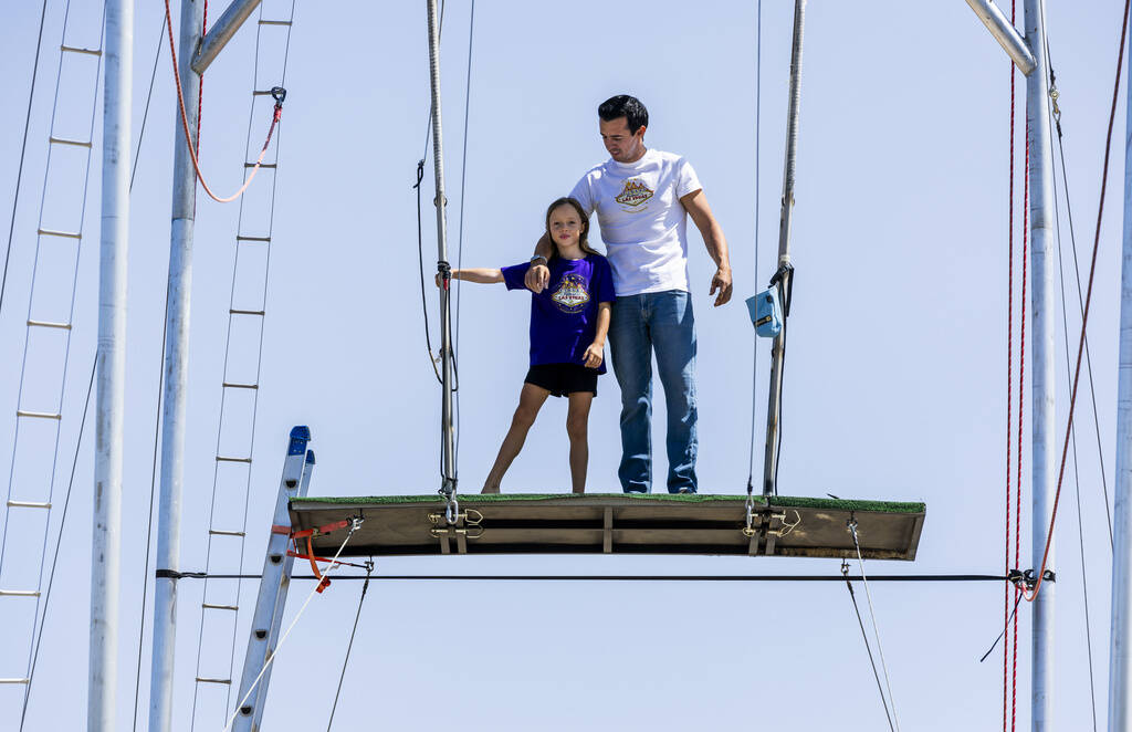 Renato Fernandes with his daughter Katalina standing atop of a platform on their backyard trape ...