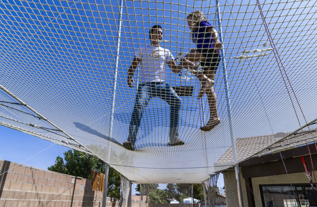 Renato Fernandes with his daughter Katalina atop of the netting on their backyard trapeze on Sa ...