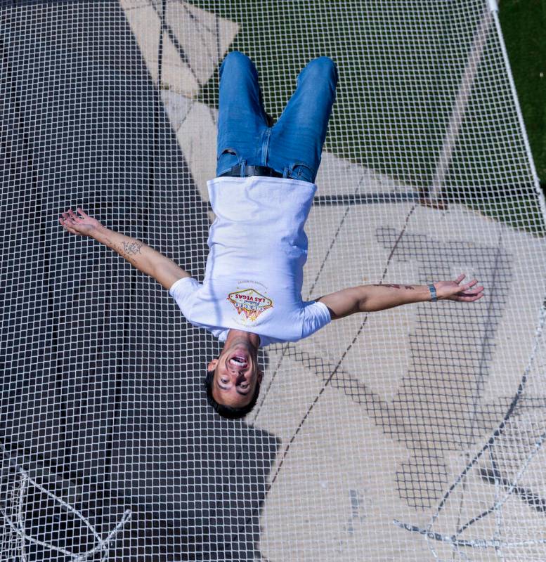 Renato Fernandes completes a backflip atop of the netting on his backyard trapeze on Saturday, ...