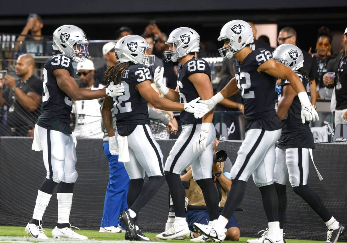 Raiders wide receiver Tyreik McAllister (32) celebrates his punt return touchdown with his team ...