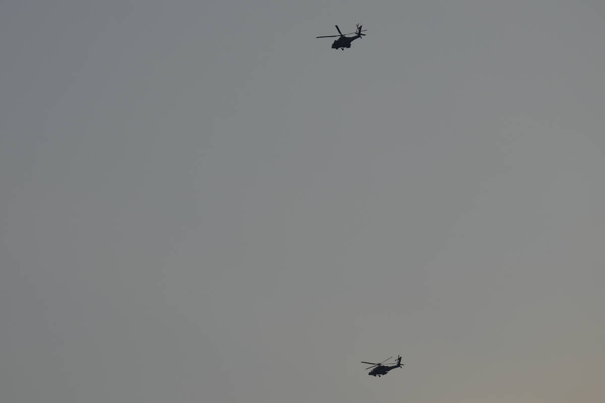 Israeli Apache helicopters fly toward northern Israel, Sunday, Aug. 25, 2024. (AP Photo/Ariel S ...