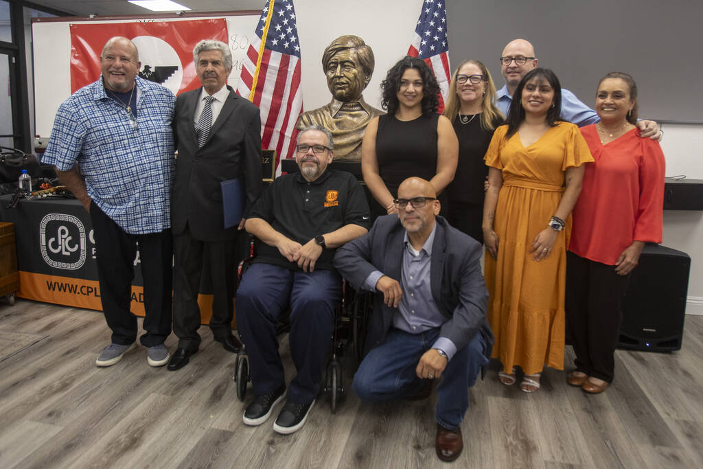 Members of Chicanos Por La Causa Nevada take a group photograph with the bust sculpture of Amer ...