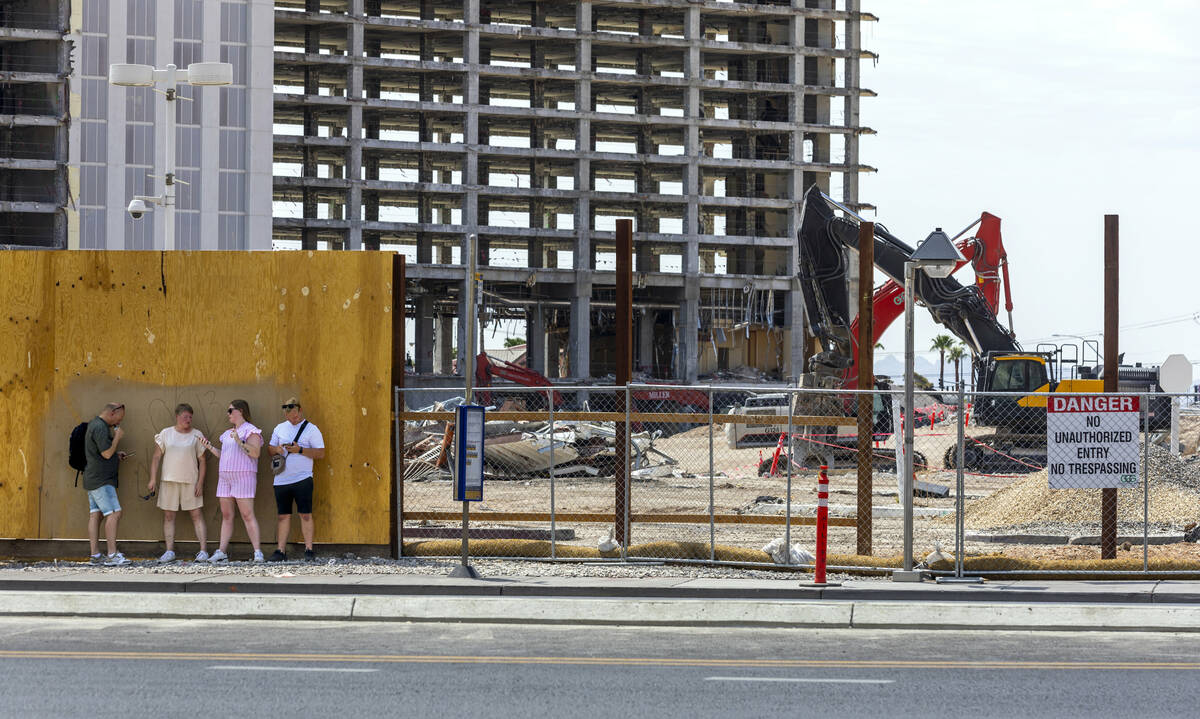 Pedestrians stop and talk as the deconstruction of the Tropicana continues by GGG Demolition, I ...