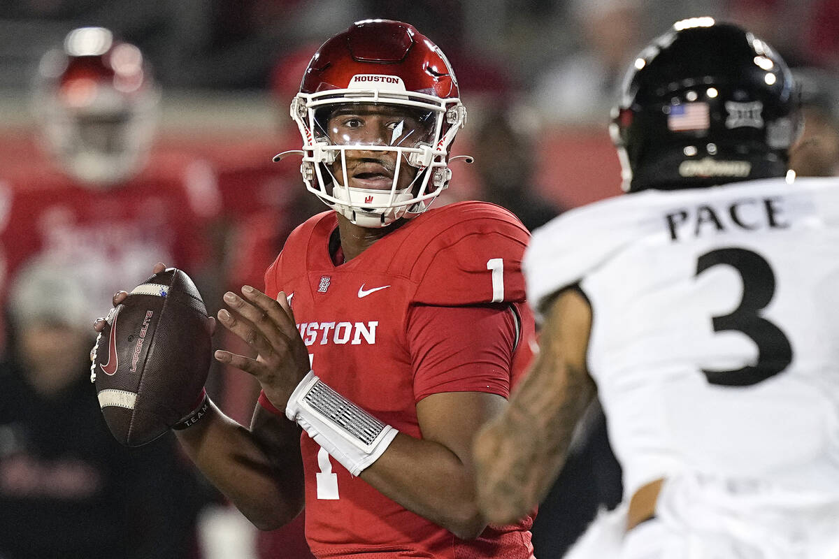 Houston quarterback Donovan Smith (1) looks for a pass under pressure from Cincinnati safety De ...