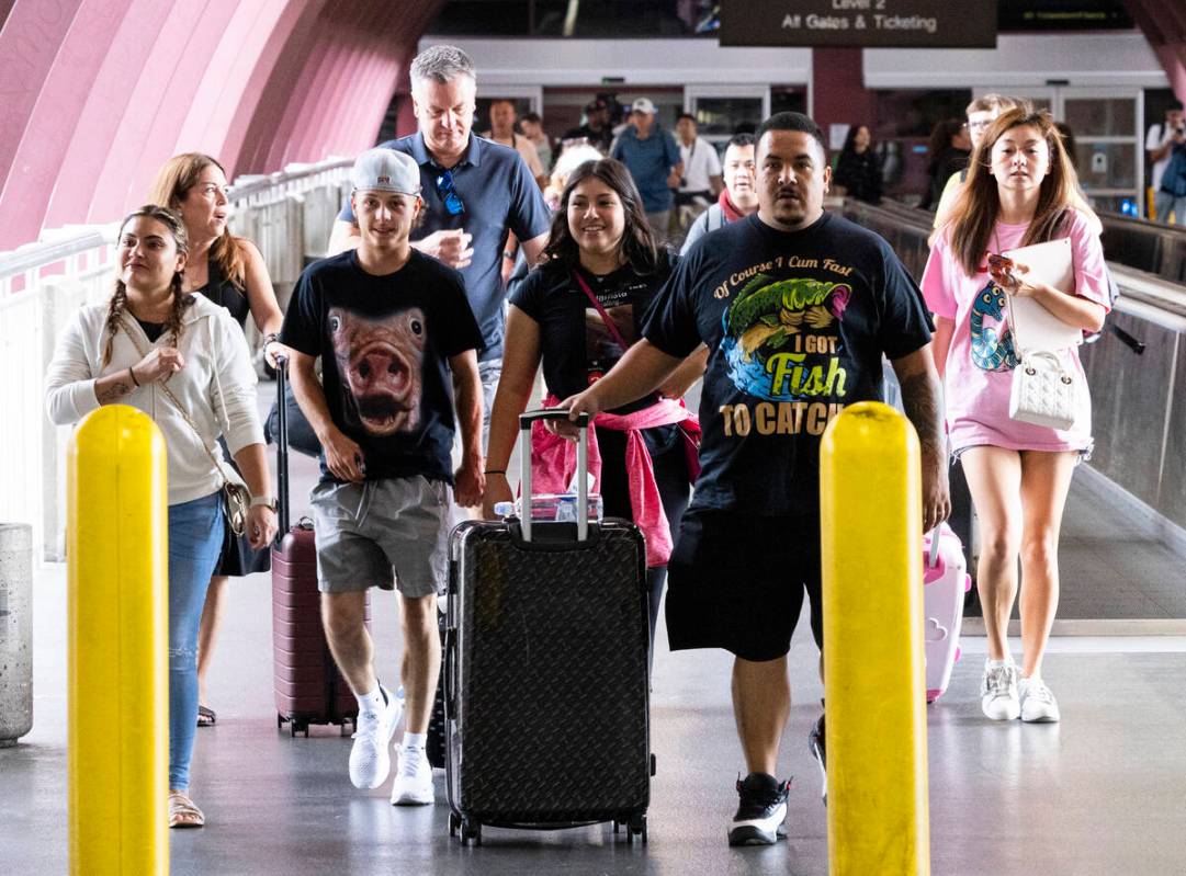 Arriving passengers head to the parking garage and Ride Share pickup location in Terminal 1 of ...