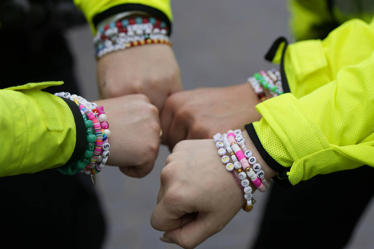 Four police officers show their wrist bands that have names of Swift songs as fans of singer Ta ...