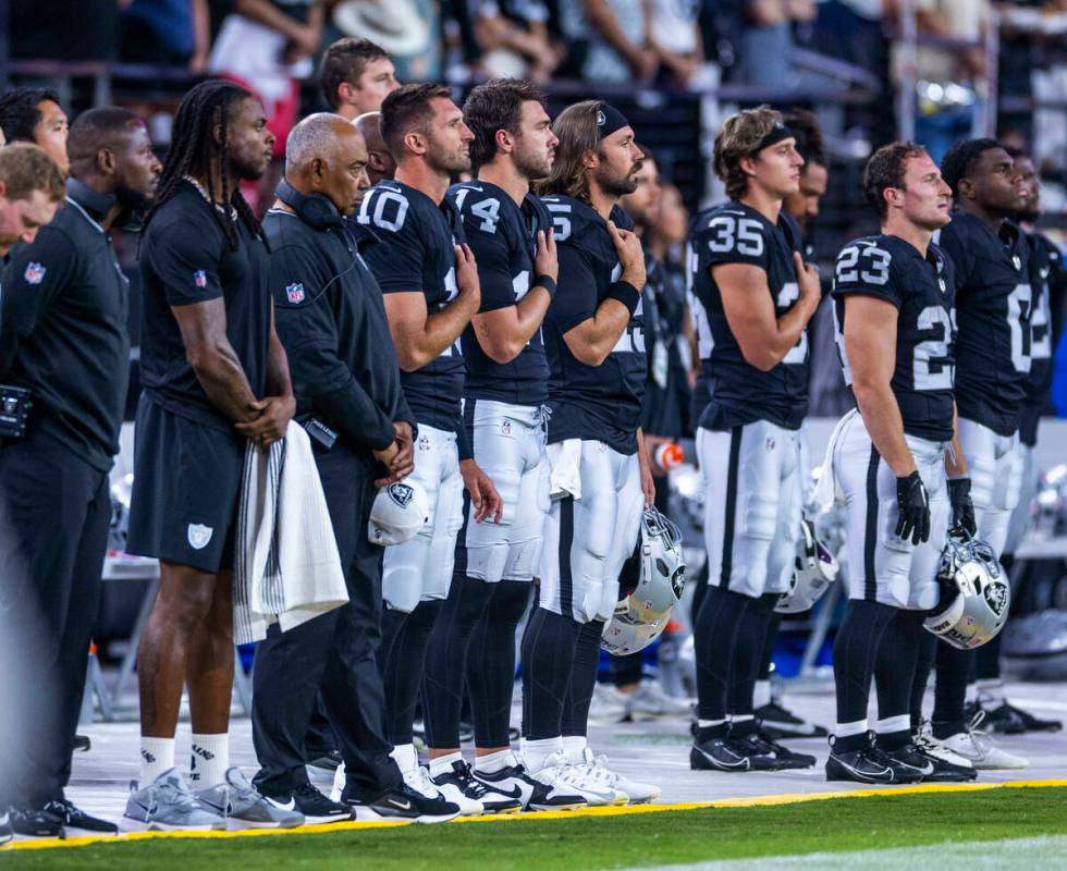 Raiders wide receiver Davante Adams (17) and teammates stand for the National Anthem as they fa ...