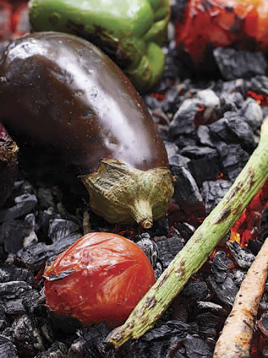 This image released by Workman Publishing Group shows grilled vegetables, including eggplant, t ...