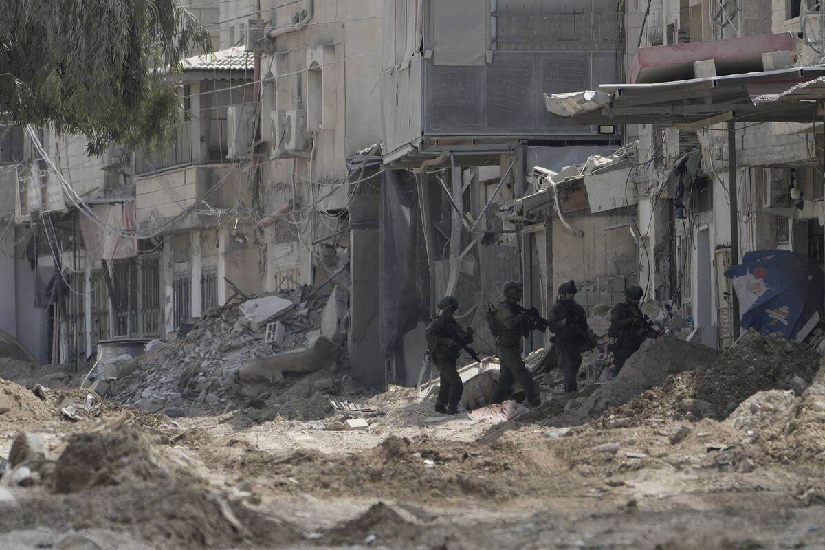 Members of Israeli forces patrol a street during a military operation in the West Bank refugee ...