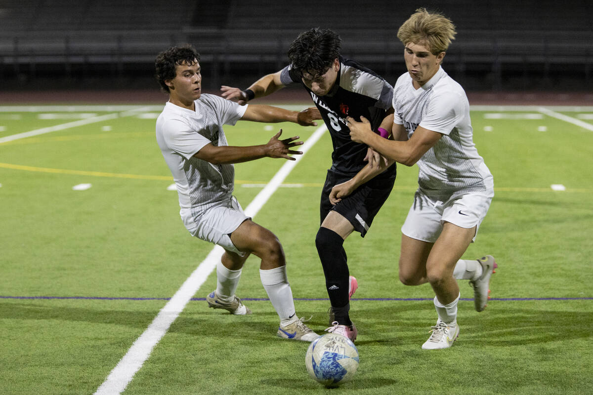 Las Vegas High senior Oscar Sandoval, center, fends off Palo Verde senior Noah Colindres, left, ...