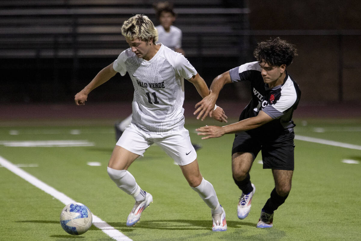 Palo Verde junior Noah Johnson (11) keeps the ball away from Las Vegas High senior Abraham Truj ...