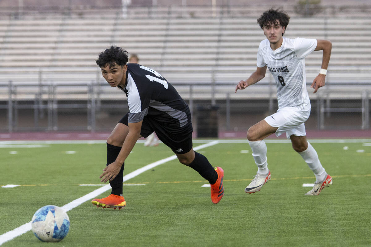 Las Vegas High junior Cesar Ruelas (14) and Palo Verde junior Josemartin Ospina (8) run after t ...