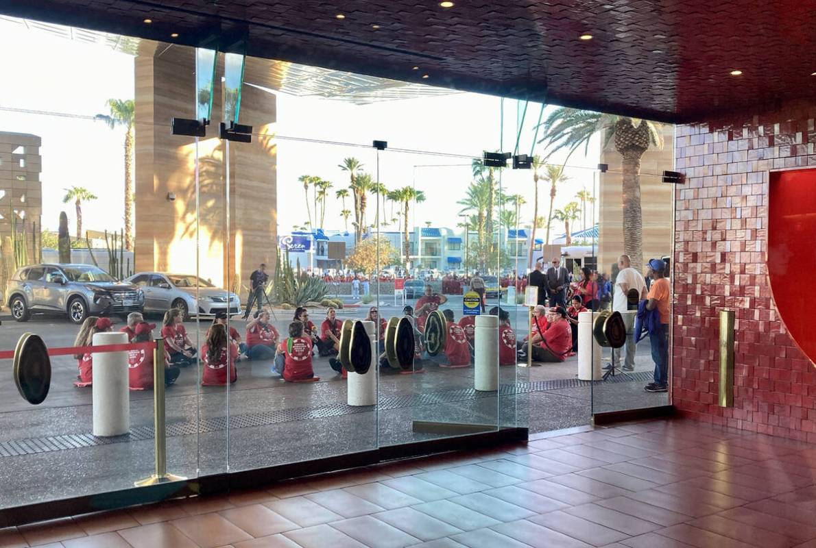 Nearly two dozen Culinary Union members sit down in the entrance to Virgin Las Vegas during a p ...