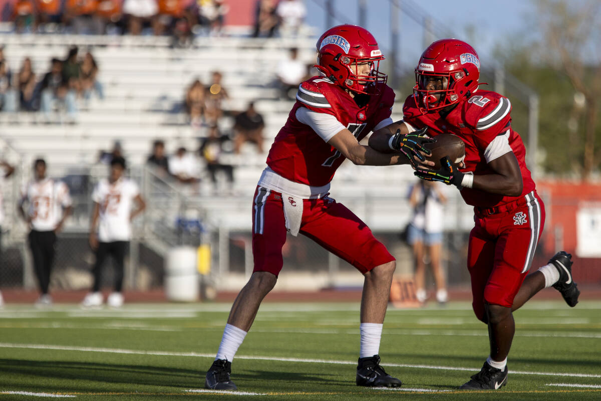 Arbor View quarterback Thaddeus Thatcher (7) hands the ball to running back Sean Moore (2) duri ...