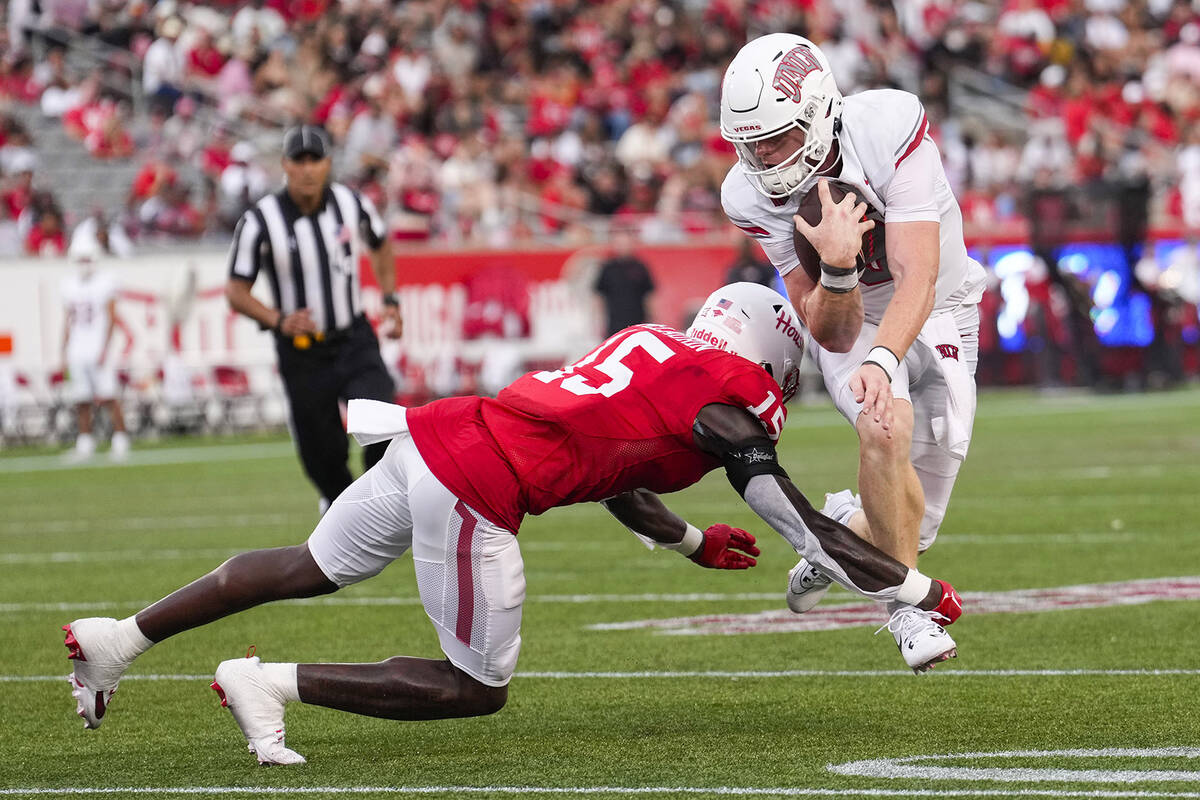 UNLV quarterback Matthew Sluka (3) leaps past Houston defensive back Hershey McLaurin (15) as h ...