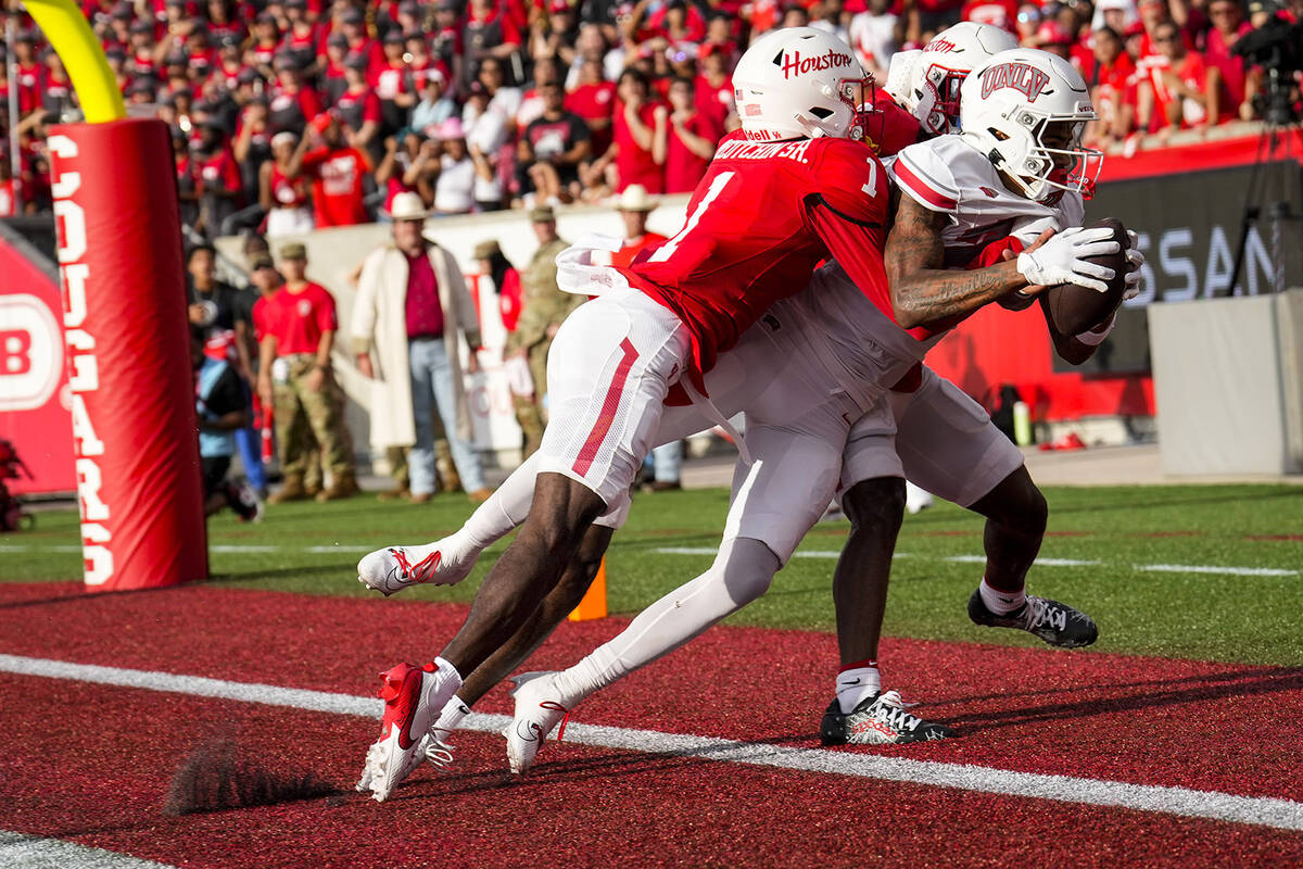 UNLV wide receiver Jaden Bradley is pushed out of the back of the end zone by Houston defensive ...