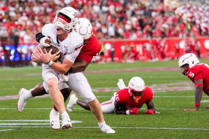 UNLV quarterback Matthew Sluka (3) is hit by Houston defensive lineman Anthony Holmes Jr. (18) ...